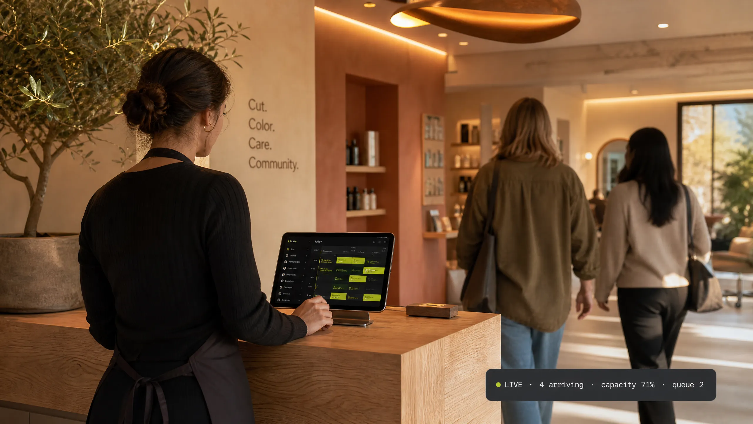 A studio front desk at rush hour — the team attends members while the live view carries the day
